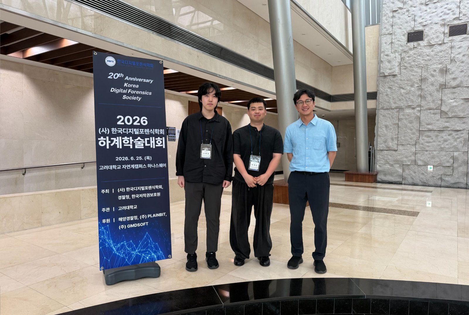 2026 한국디지털포렌식학회 20주년 기념 하계학술대회 안내판 앞에서 찍은 기념사진